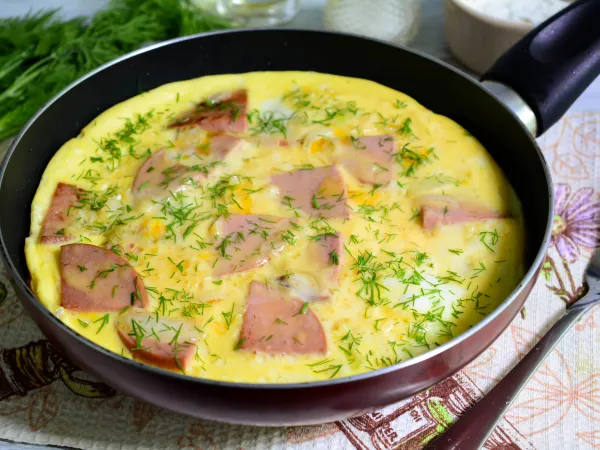 Фото готового блюда: Омлет с луком и колбасой на сковороде