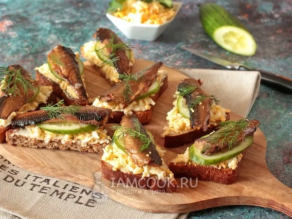 Фото готового блюда: Чесночные гренки с яйцом, шпротами и огурцом